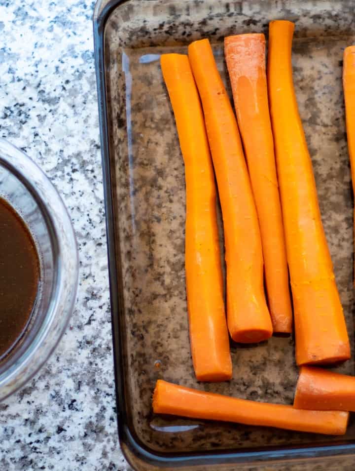 carrots in baking dish with marinade beside