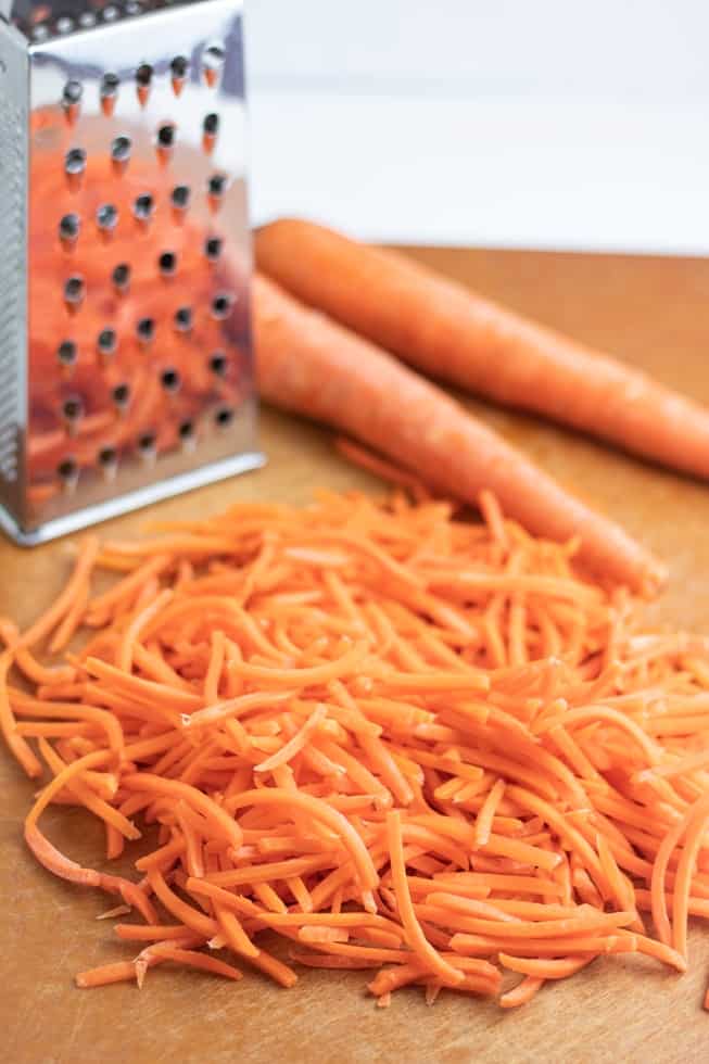 grated carrots on cutting board with grater