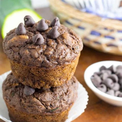 chocolate zucchini vegan muffins two stacked with chocolate chips in background