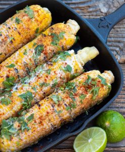 Mexican corn in black cast iron pan with lime wedge