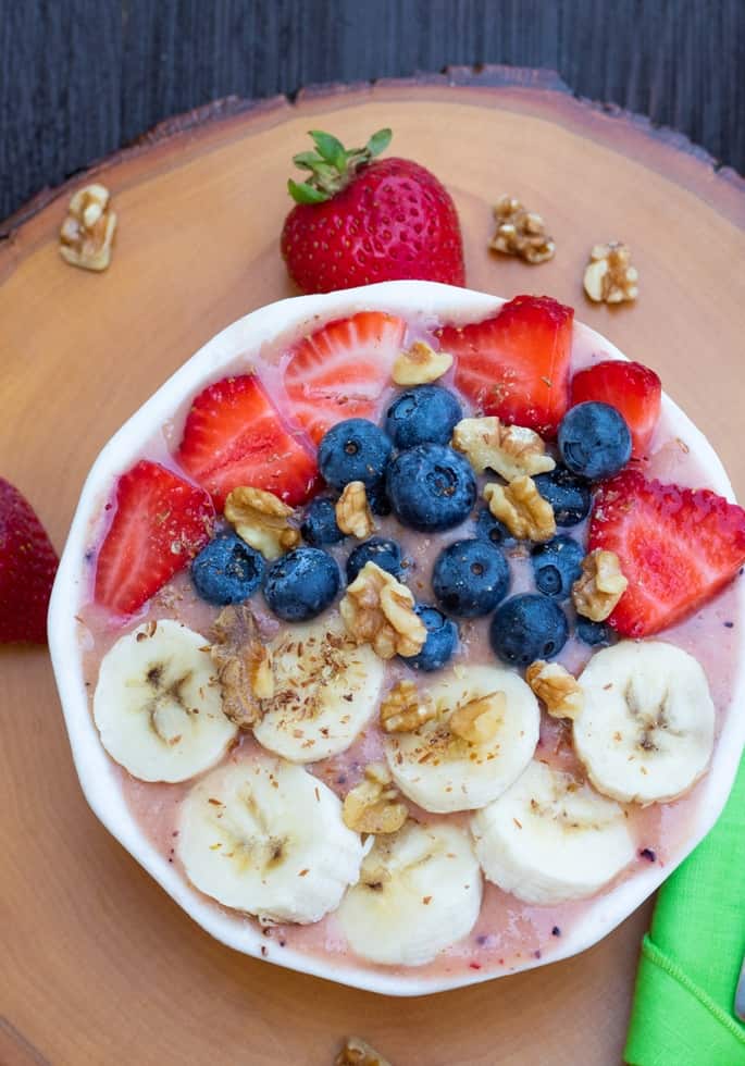 overhead shot of smoothie bowl topped with berries and bananas
