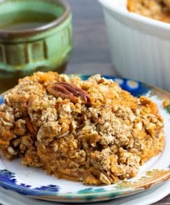 serving of sweet potato casserole on colorful plate with coffee cup in background