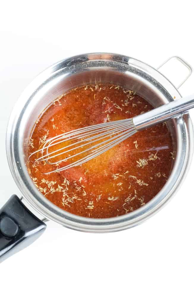oil free tomato salad dressing cooking in stainless pot with whisk