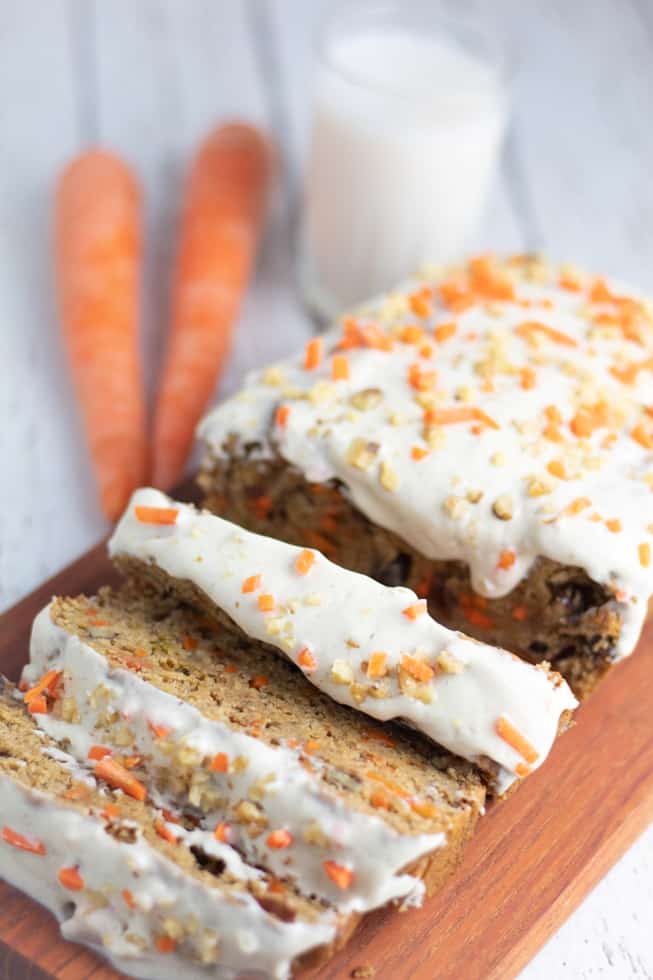 vegan carrot cake loaf with 3 pieces sliced carrots and milk in background