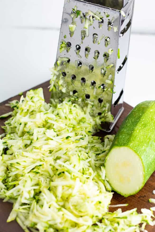 grated zucchini with grater in background
