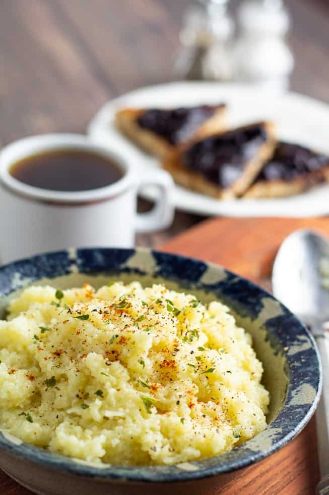 bowl of healthy grits with coffee and toast in background