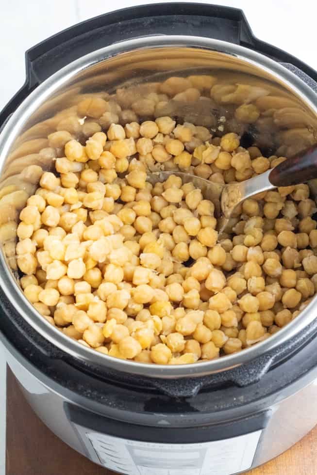 overhead photo of cooked chickpeas in instantpot with spoon