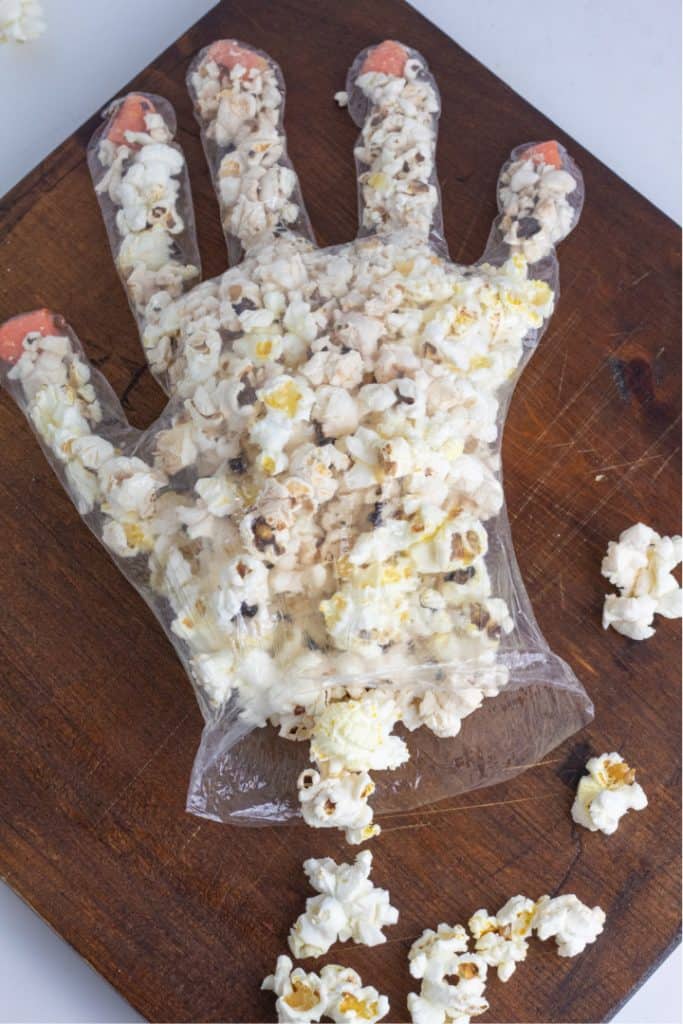 clear plastic glove being stuffed with popcorn