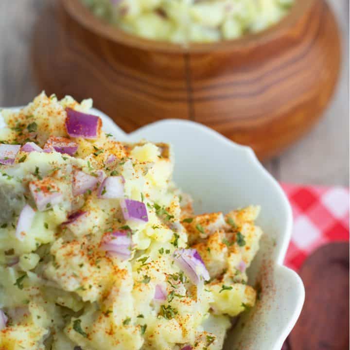 close up of vegan potato salad in white bowl
