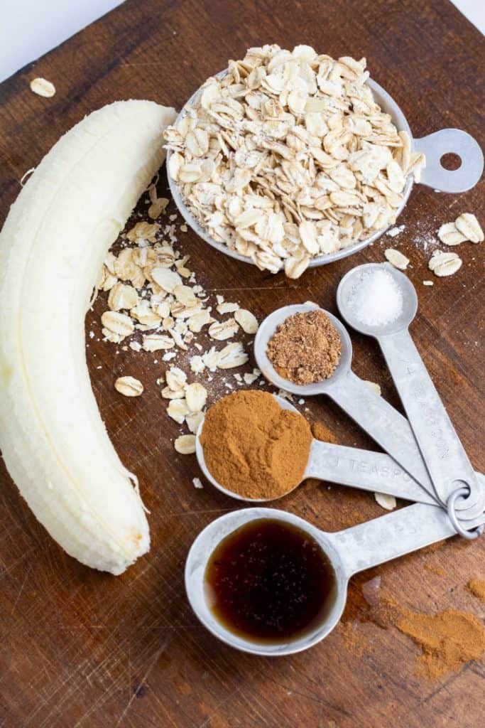 peeled banana, oats, and spices on wooden board