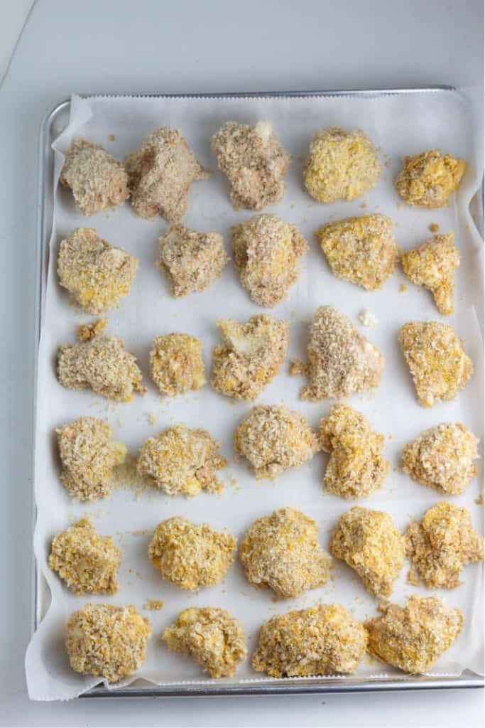 breaded cauliflower on baking sheet with parchment paper