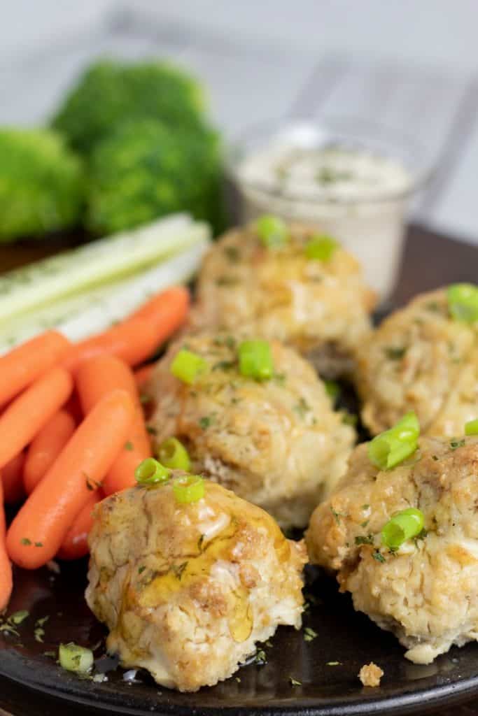 cauliflower buffalo wings on black plate with carrots and celery sticks