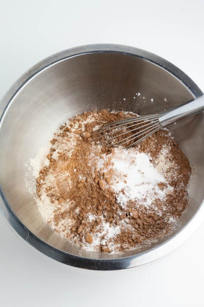 Chocolate cake dry ingredients in stainless mixing bowl with whisk
