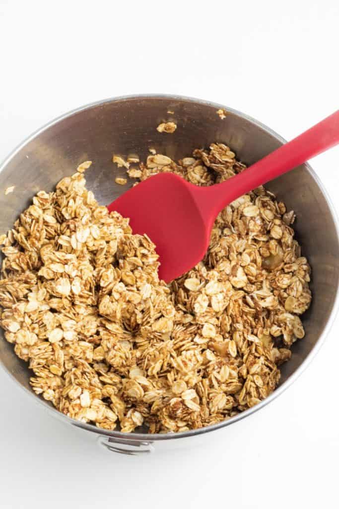 stainless bowl with red spoon and oats