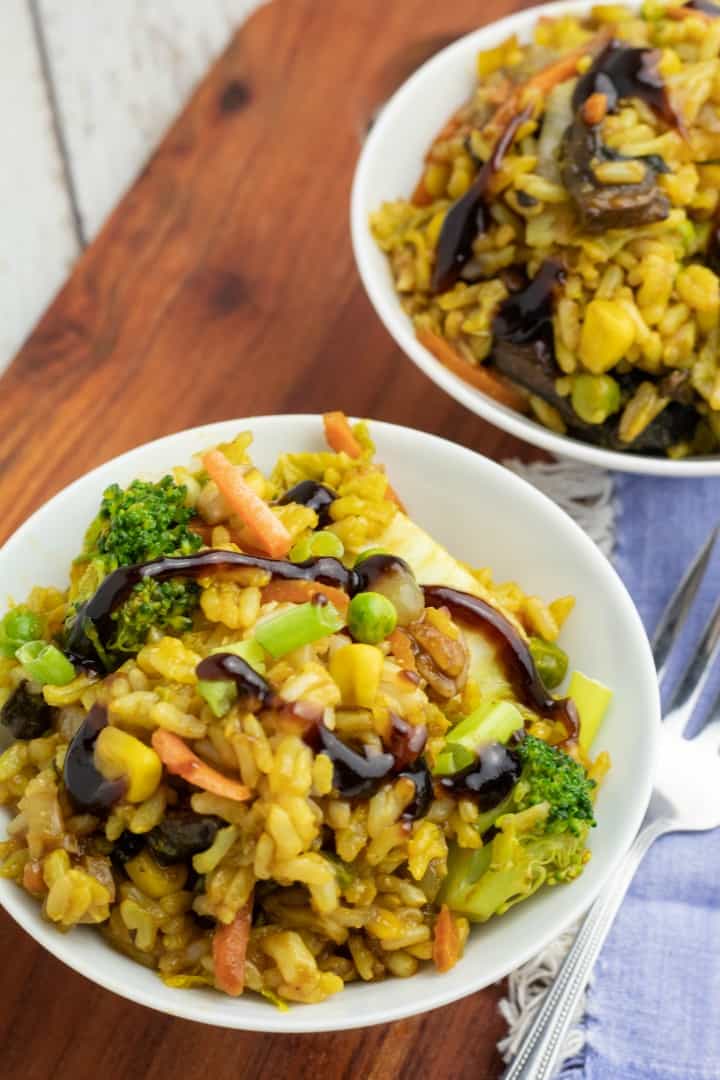 healthy stir fried rice in white bowls on wooden board