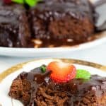 sice of chocolate cake on white plate topped with strawberry