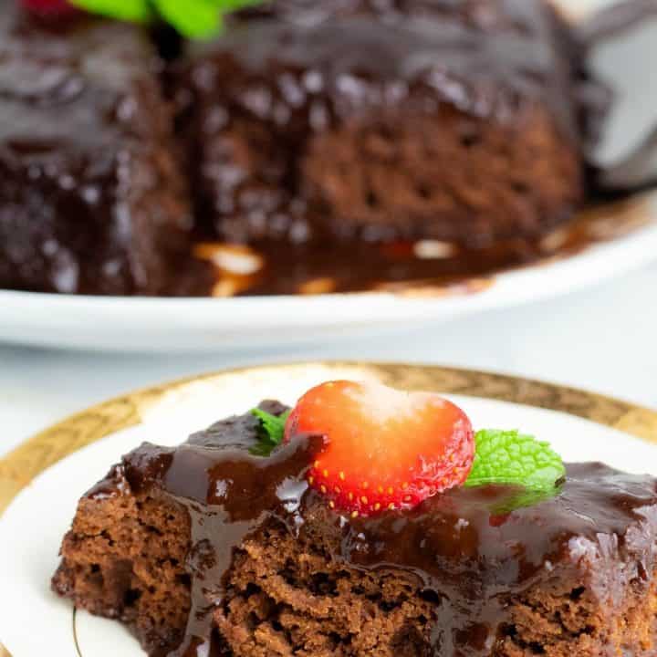 sice of chocolate cake on white plate topped with strawberry
