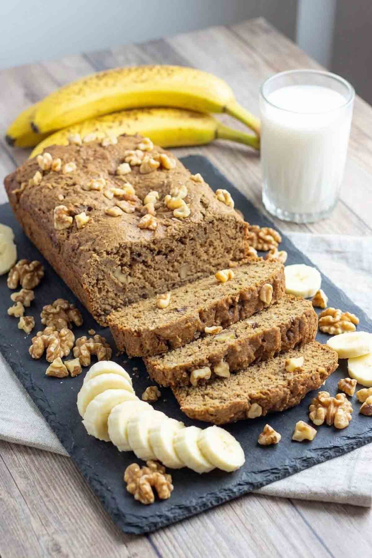 a loaf of banana bread sliced on a cutting board.