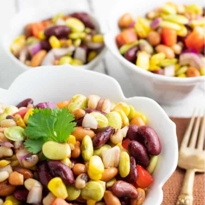 mixed bean salad topped with cilantro in white bowl
