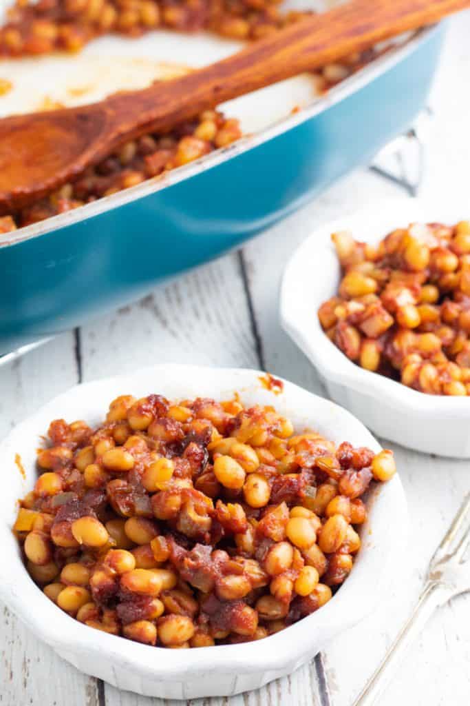 white bowls filled with baked beans and casserole dish in background