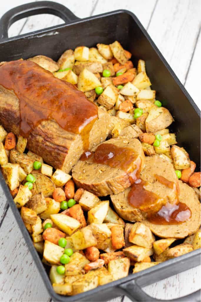 vegan roast with roasted potatoes and carrots in cast iron baking dish