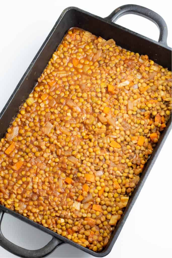 cast iron casserole dish with lentils in it
