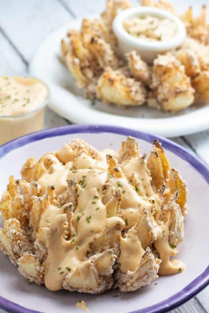blooming onion on plate with vegan chipotle sauce