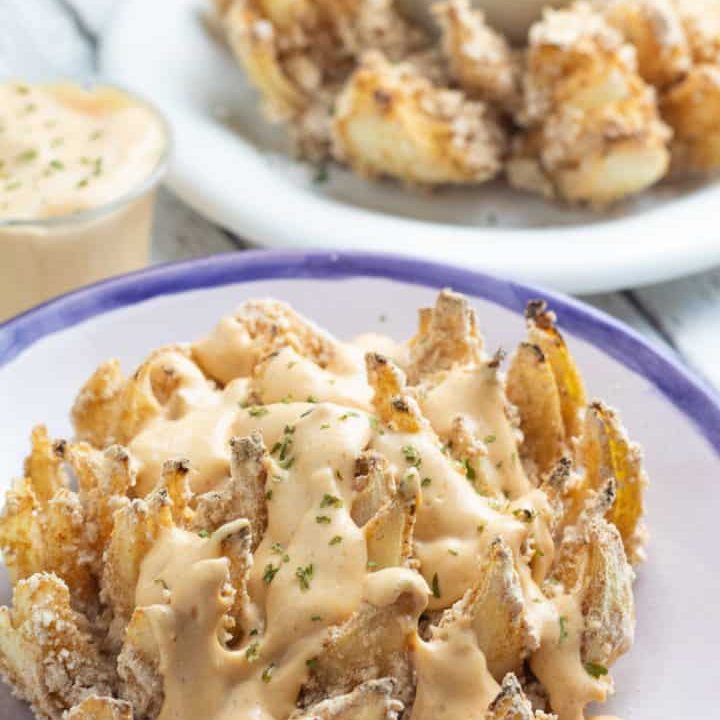 blooming onion on plate with vegan chipotle sauce