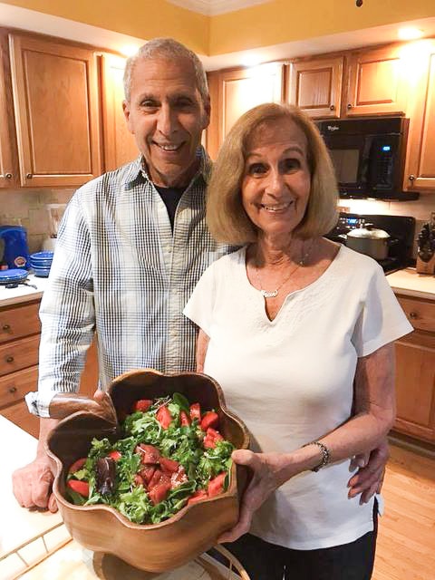 bob and fran german in kitchen holding bowl of salad