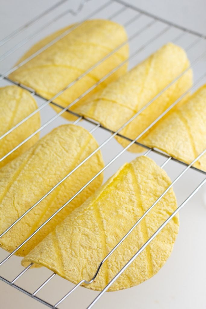 corn tortillas draped over oven rack cooking