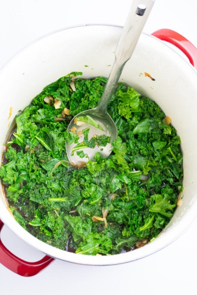 cooked kale in large stockpot with spoon