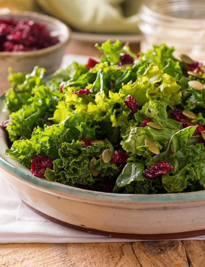 kale salad with raisins in bowl