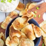 crispy homemade potato chips in blue bow with dip in background