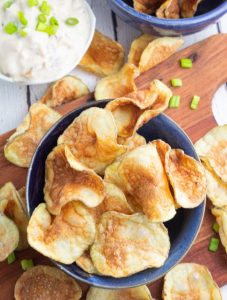 crispy homemade potato chips in blue bow with dip in background