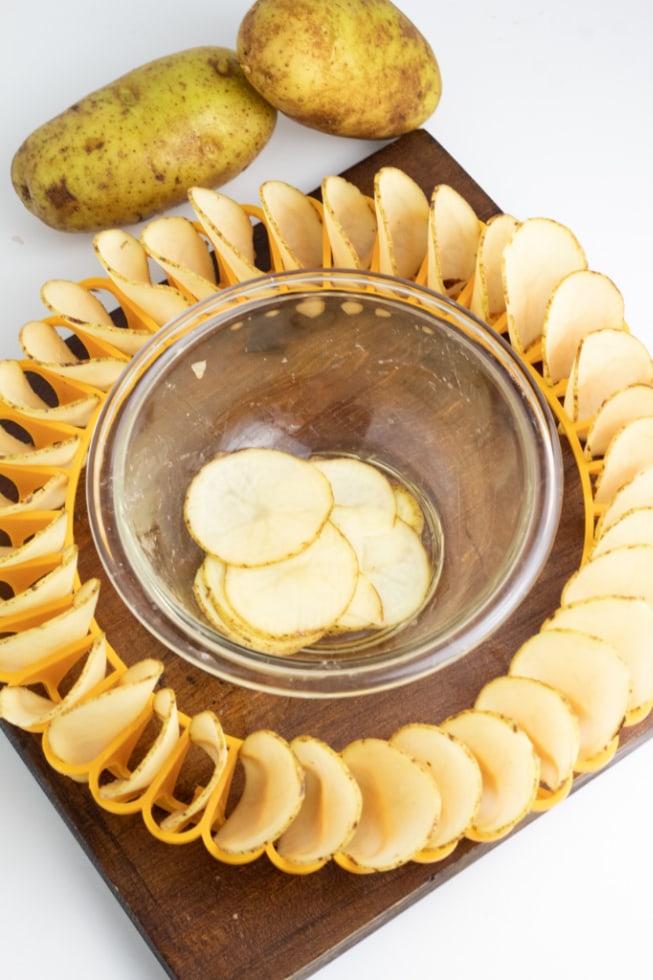 raw sliced potatoes in microwave ring with bowl in middle