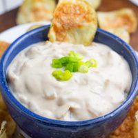 bright blue bowl with vegan french onion dip and potato chips