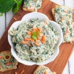 overhead photo of vegan spinach dip in white bowl with crackers
