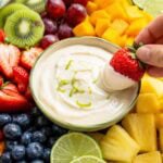 platter of fresh fruit with a bowl of creamy lime dip in the middle.