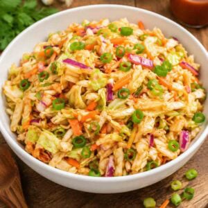 red slaw in a white bowl on rustic table.