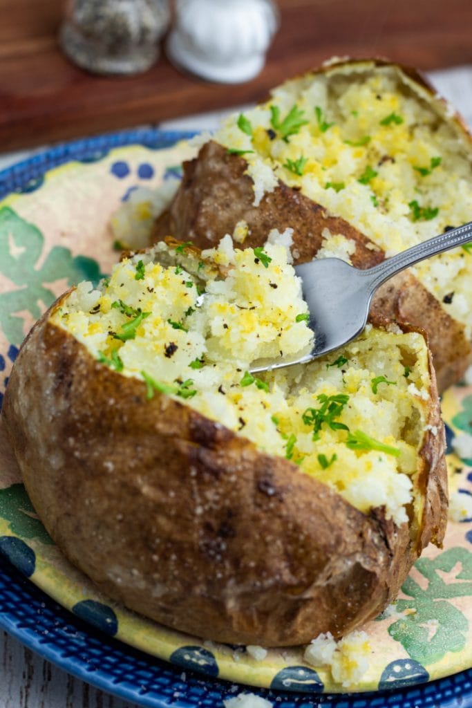 close up of baked potatoes with forkful of potato