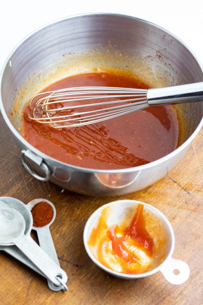 ketchup and spices in bowl with whisk