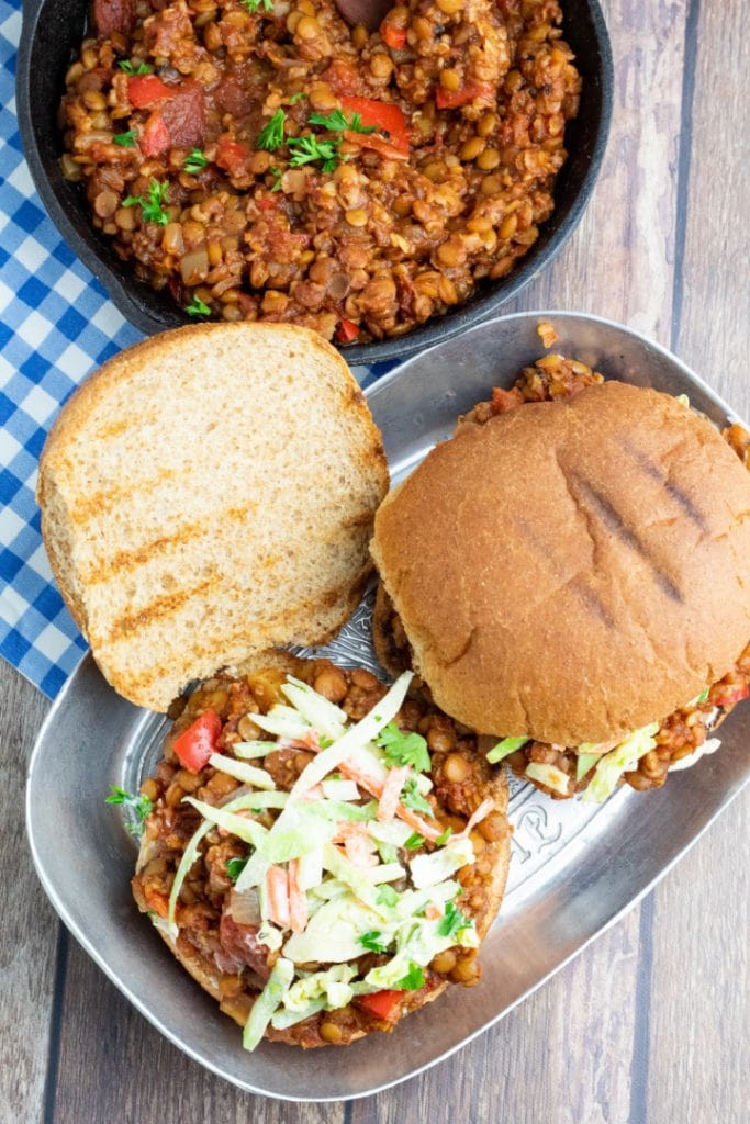 Overhead shot of sloppy joe sandwiches on plater with one open and other with top bun