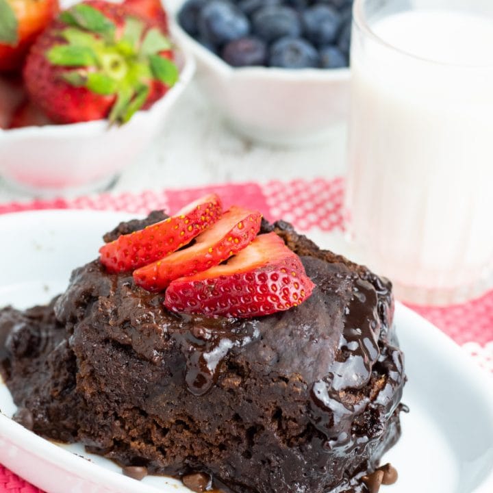 slice of chocolate crockpot lava cake topped with strawberry slices