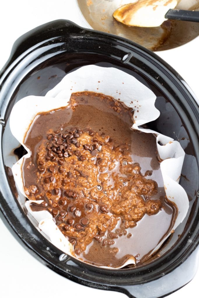 slow cooker with choco cake batter and frosting