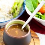 Japanese saucer with miso sauce with salad and rice in background