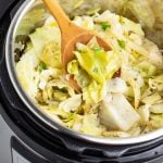 instant pot full of cooked cabbage with a wooden spoon
