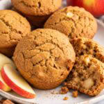 applesauce cinnamon muffins on a plate with one cracked open.