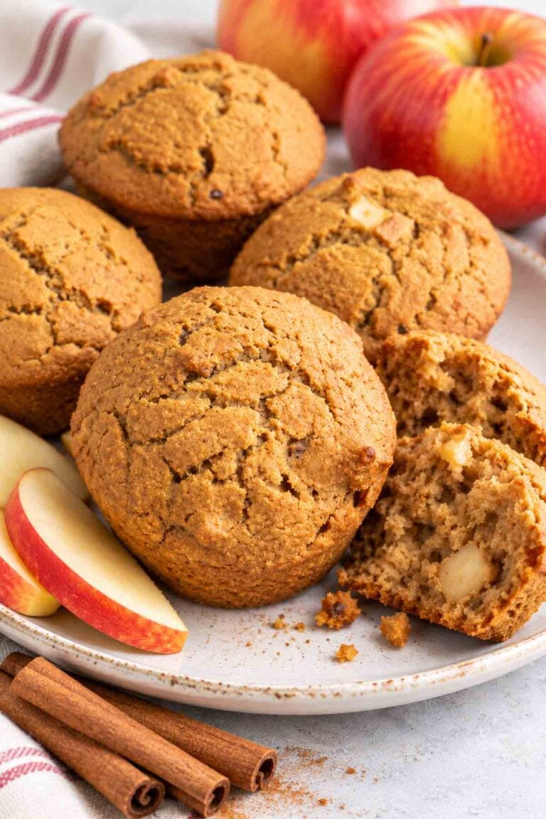 applesauce cinnamon muffins on a plate with one cracked open.