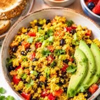 big bowl filled with loaded tofu scramble with avocado slices.