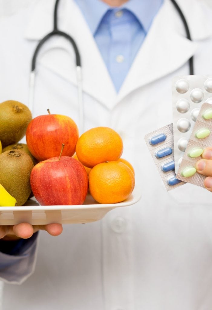 doctor holding tray of fruit and pills